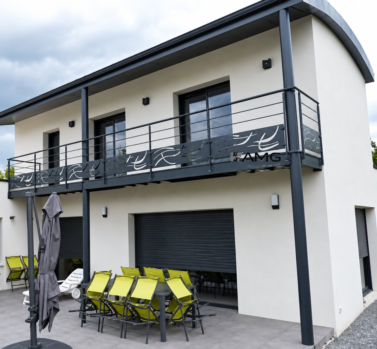 Maison contemporaine blanche avec terrasse, balcon et garde-corps métallique.